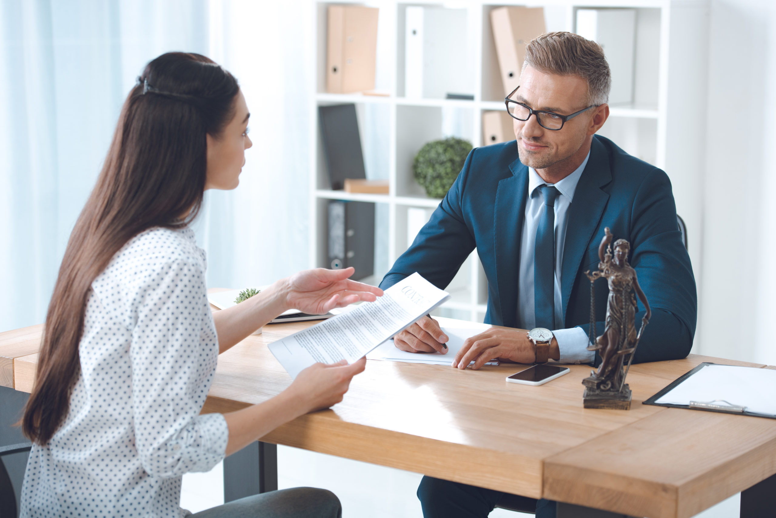 Lawyer discussing legal documents with a client in an office setting.