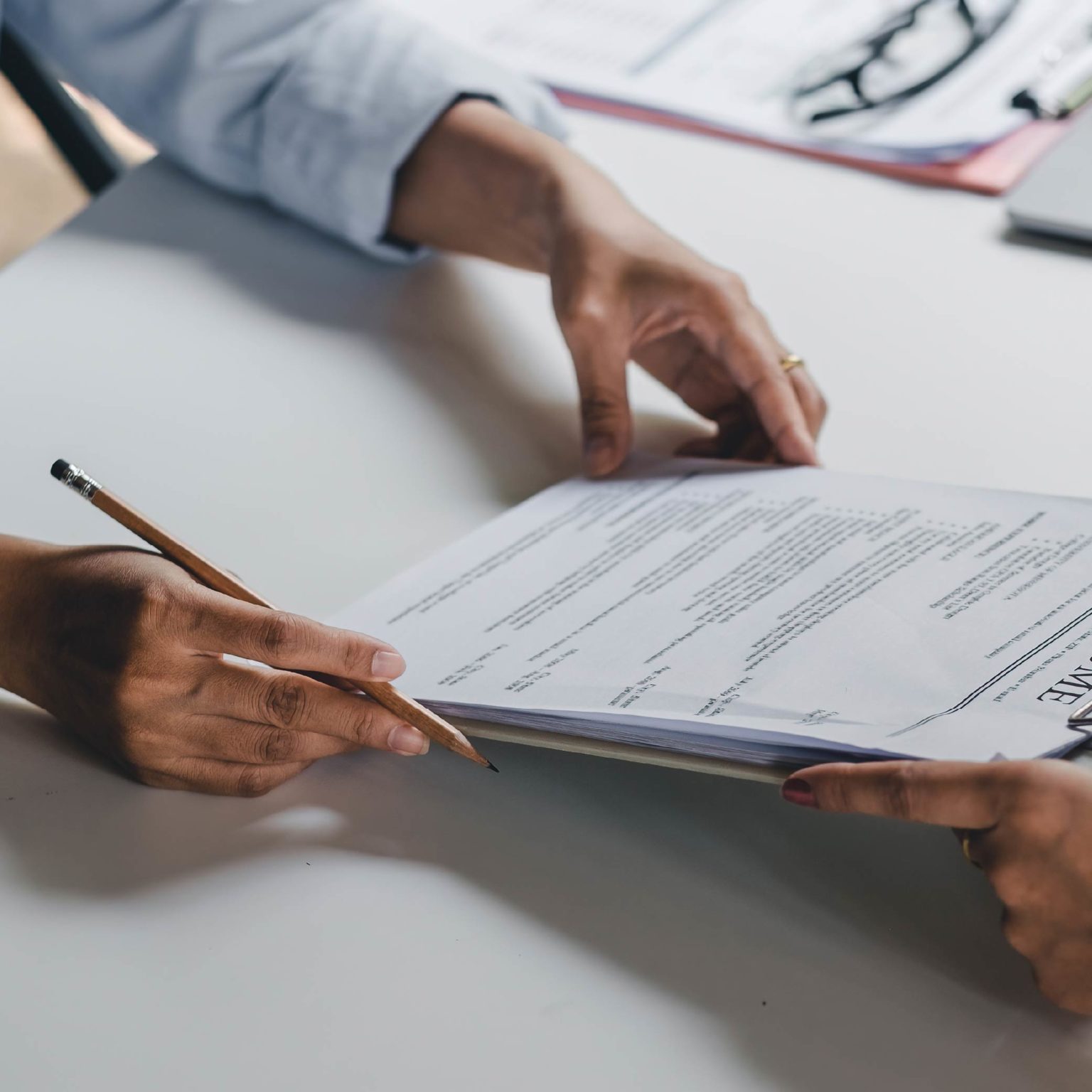 Two professionals signing documents, representing work visa applications and legal steps in South Africa's immigration process.